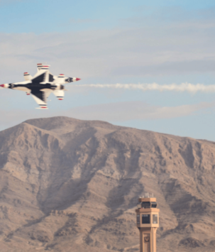 Military plane flying over desert mountain