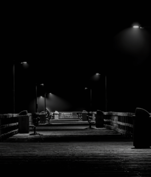 Boardwalk pier at night lit by street lamps