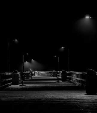 Boardwalk pier at night lit by street lamps
