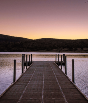 Evening light on a dock overlooking a lake with mountain horizon landscape