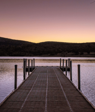 Evening light on a dock overlooking a lake with mountain horizon landscape
